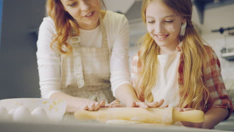 Close-up-of-the-mother-and-daughter-having-fun-while-making-a-daugh-for-cookies-in-the-kitchen-room.-Portrait-shot.-Indoor